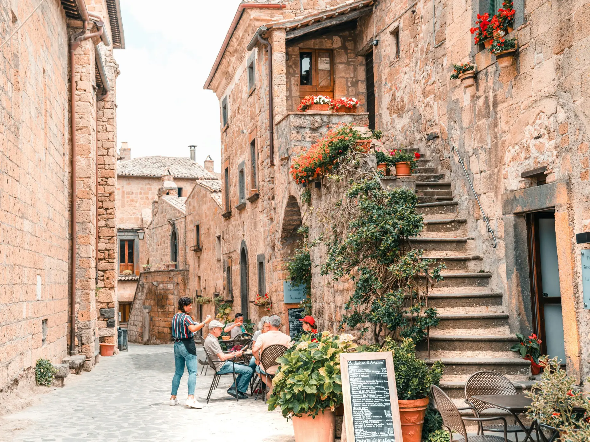 A medieval hilltop village of Civita di Bagnoregio perched on an eroding tufa cliff in central Italy, connected to the valley below by a narrow pedestrian bridge