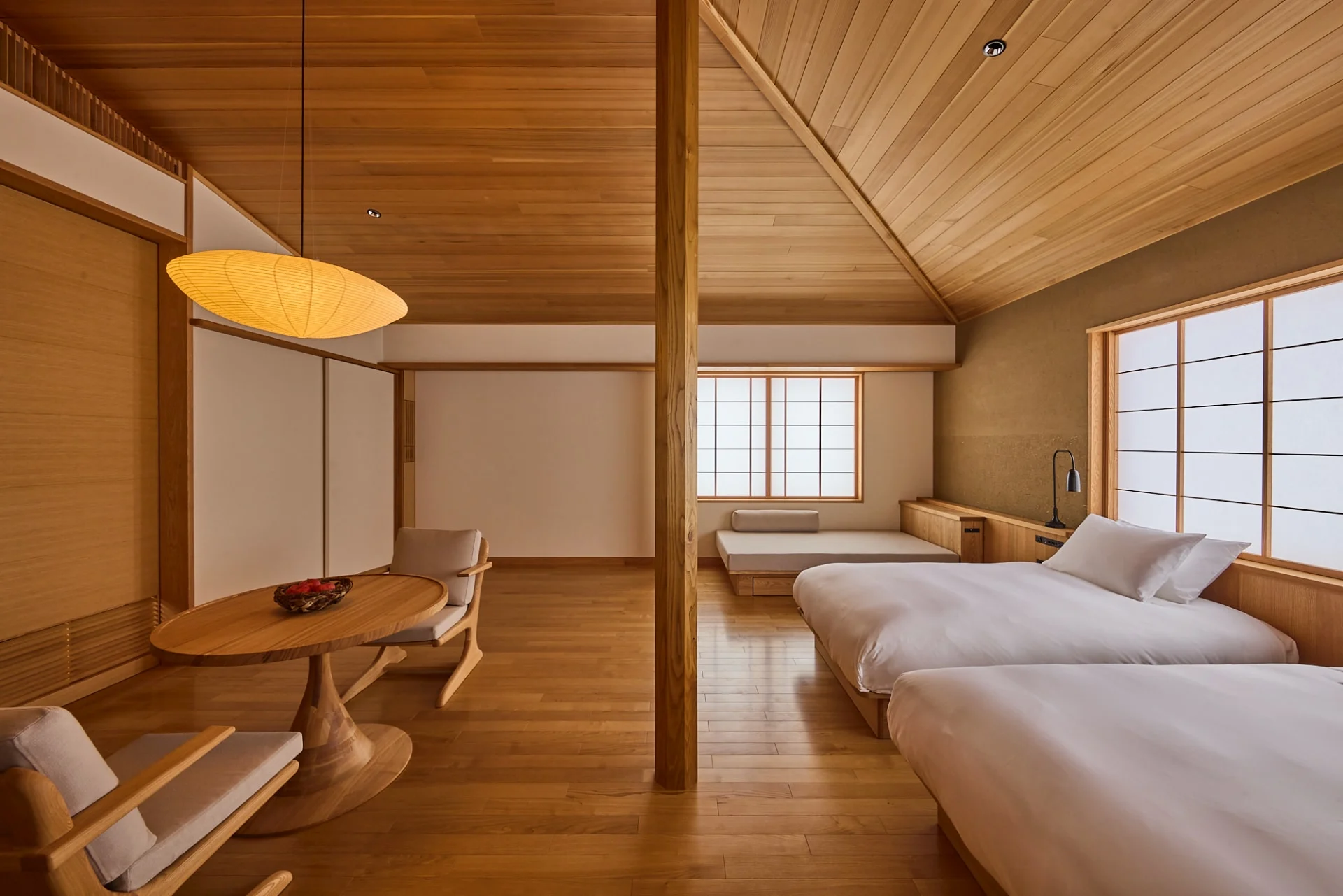 Traditional Japanese guest room at Azuma Farm Koiwai in Iwate Prefecture, Japan, featuring warm wood interiors, low beds, and shoji screens