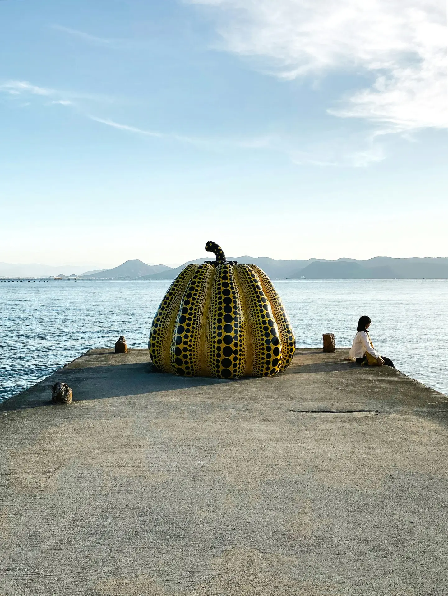  Yayoi Kusama's yellow pumpkin sculpture on a concrete pier on Naoshima island, Japan's art architecture destination