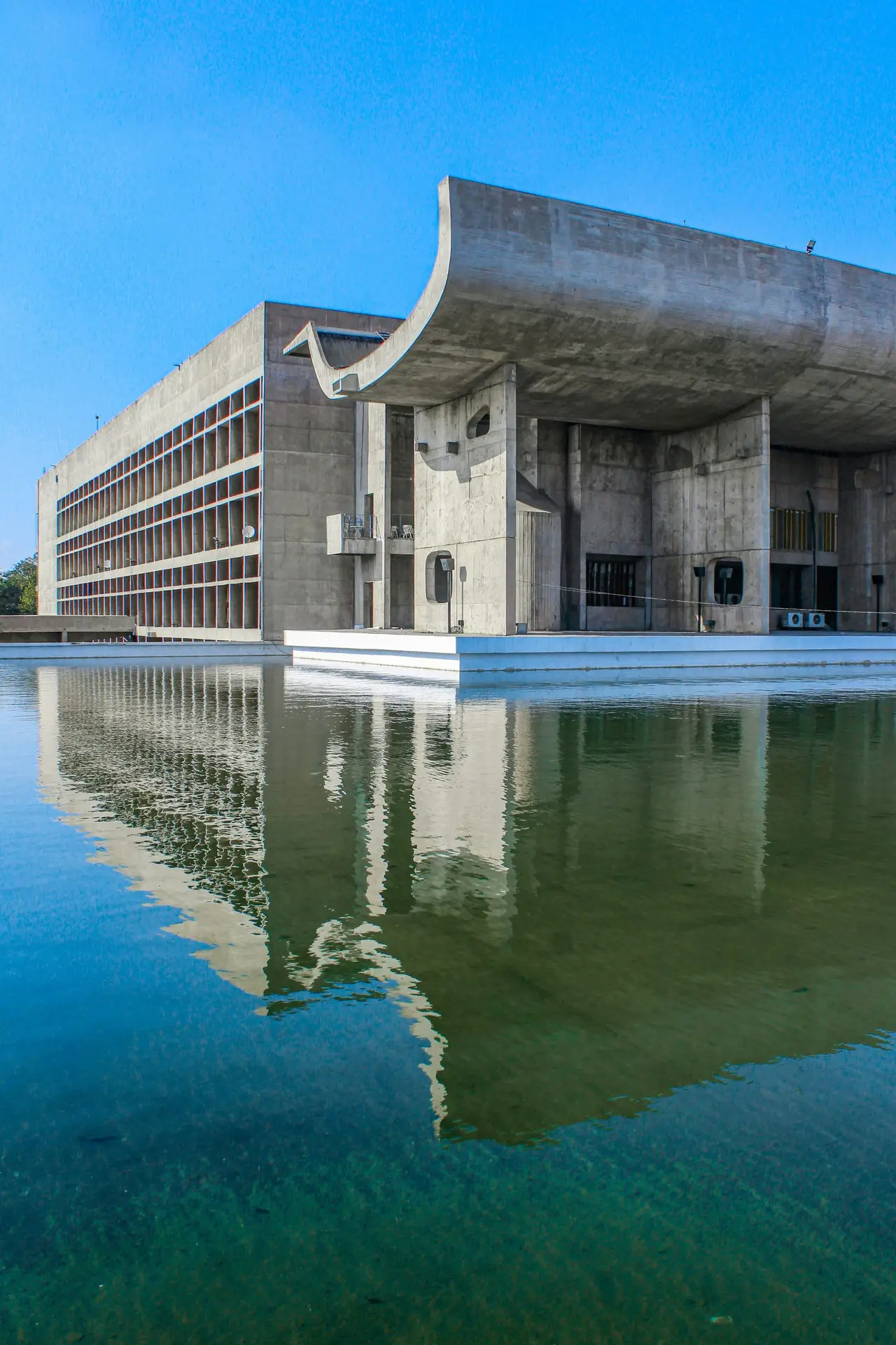 Le Corbusier's Legislative Assembly building in Chandigarh reflected in a pool, part of the UNESCO Capitol Complex