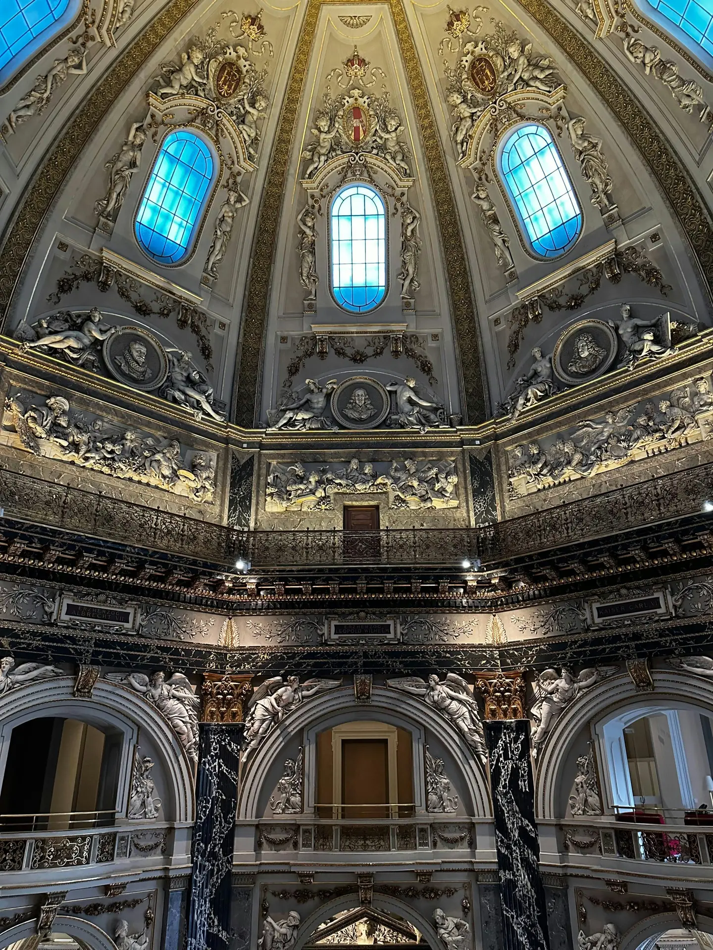 Ornate dome interior of the Kunsthistorisches Museum in Vienna with sculpted figures and stained glass windows on the Ringstrasse