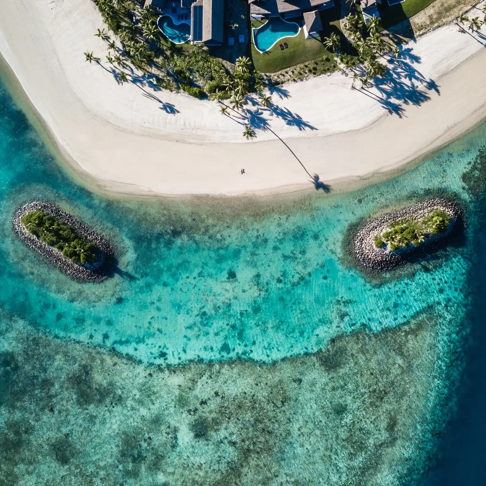 Six Senses Fiji Opens Three Beachfront Residences on Malolo Island 5 Aerial view of Six Senses Fiji Residences private beach and coral reef on Malolo Island, with two reef islets in the turquoise lagoon