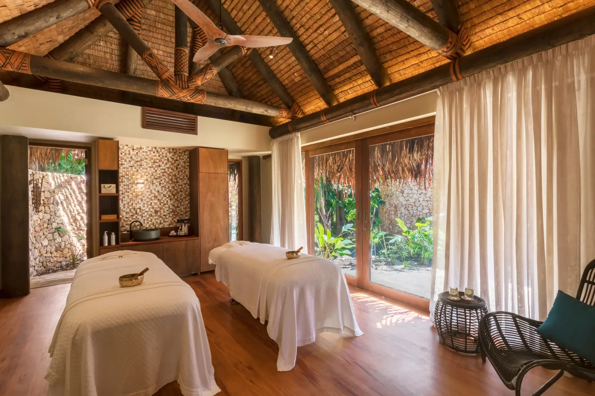 Six Senses Fiji Opens Three Beachfront Residences on Malolo Island 4 Double treatment room at Six Senses Spa Fiji with thatched roof, traditional Fijian binding, two massage tables and singing bowls