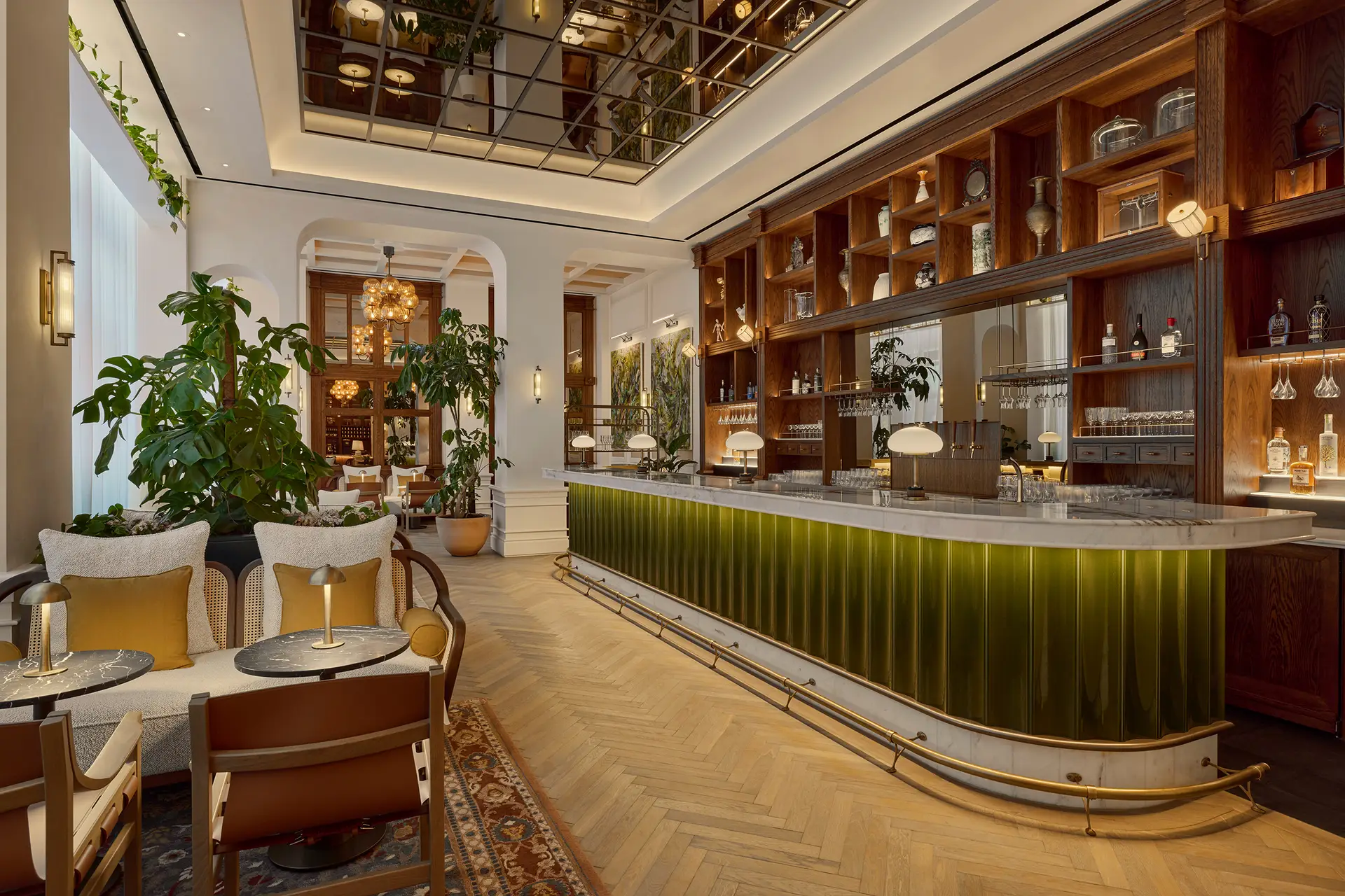 Whiteley's Bar at Six Senses London with green tiled bar front, marble countertop, and herringbone parquet flooring in the restored Whiteley building 
