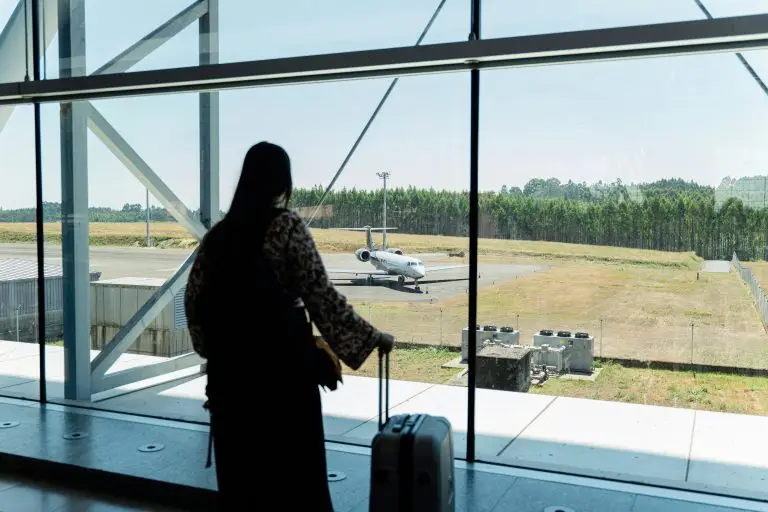 Solo travel destinations 2026: a traveler with luggage waits at an airport gate, capturing the quiet first moments before a solo trip