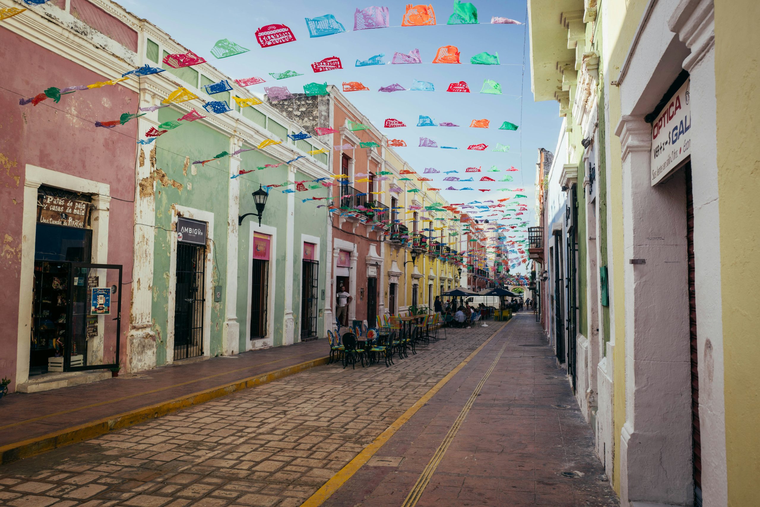 Solo travel destinations 2026: a colonial street in Mexico's Yucatan peninsula with papel picado flags, where Mérida and Oaxaca rank twelfth on the list as the safest cities in Mexico for first-time solo travelers
