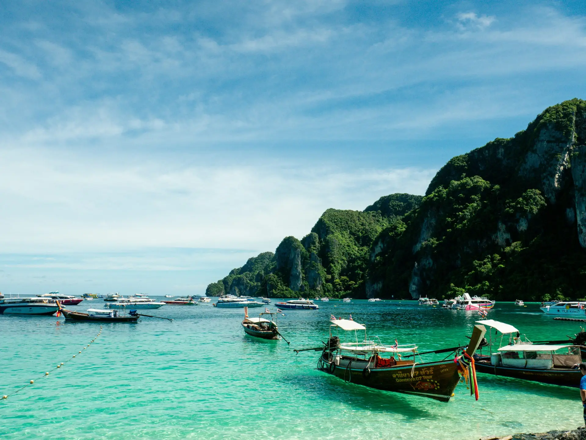 Solo travel destinations 2026: longtail boats in turquoise water near the Phi Phi Islands in southern Thailand, where Thailand ranks tenth as Southeast Asia's most established budget destination for solo travelers
