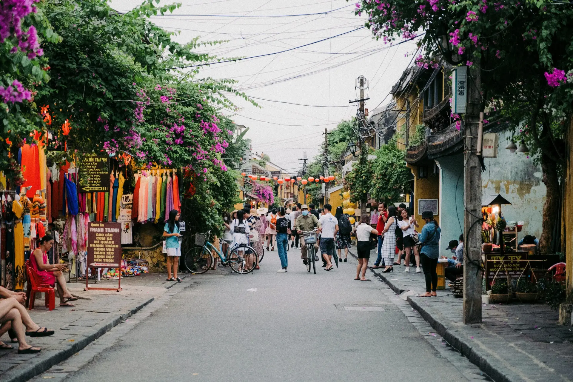 Solo travel destinations 2026: a street in Hoi An's old town in Vietnam, with yellow colonial buildings, red lanterns, and bougainvillea, where Vietnam ranks eleventh on the list as one of Asia's strongest budget destinations for solo travelers

