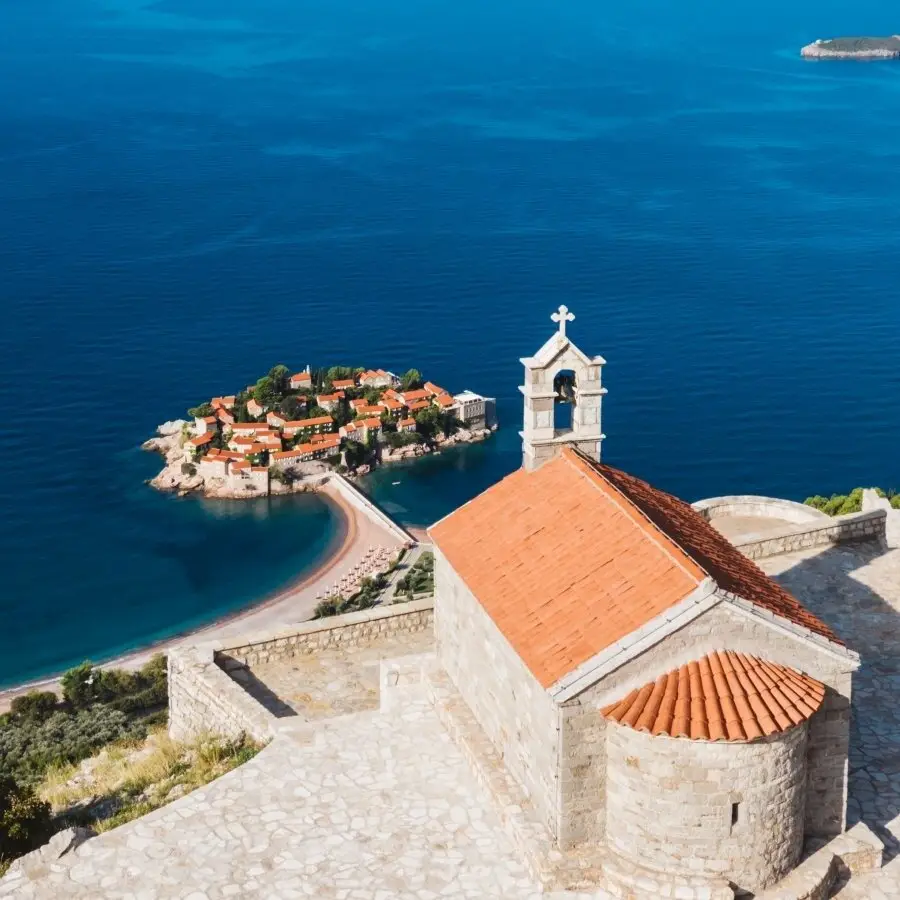 After five years, Aman Sveti Stefan reopens on the Adriatic 6 View of Sveti Stefan island from St. Sava church, showing the medieval village, sand tombolo, and Adriatic coast.