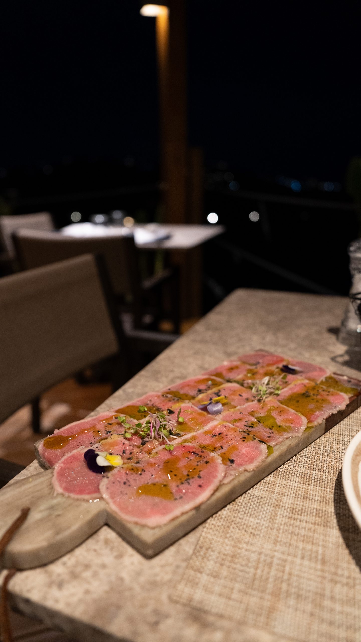 Casa Del Mar Mykonos: A Week on the Quiet Side of the Island 9 Beef carpaccio with olive oil, microgreens and edible flowers served on a marble board at Miramar restaurant, Casa Del Mar Mykonos, on the terrace at night