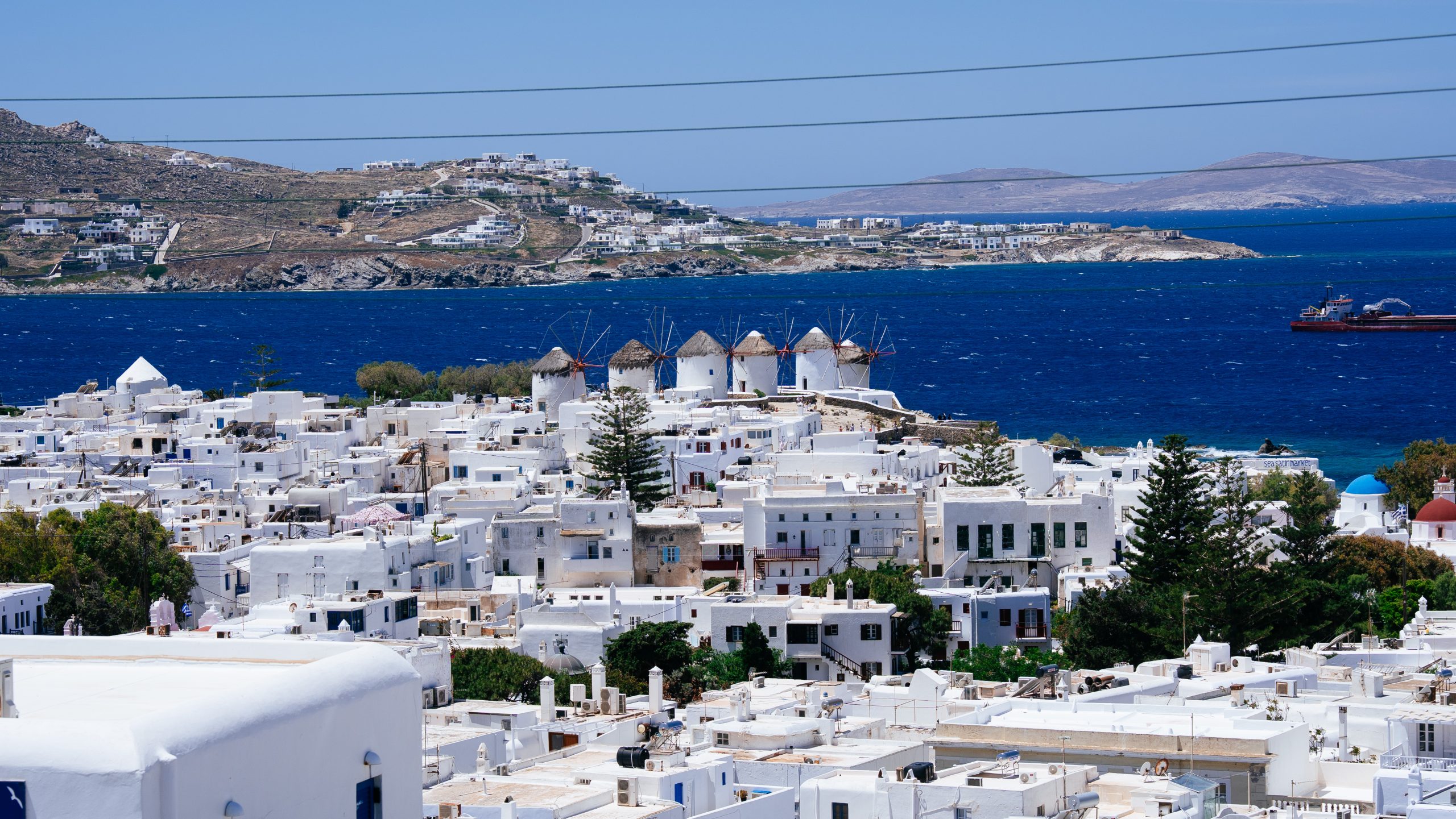 Casa Del Mar Mykonos: A Week on the Quiet Side of the Island 19 View over the whitewashed houses of Mykonos Town with the iconic hilltop windmills and a blue-domed church above the deep blue Aegean