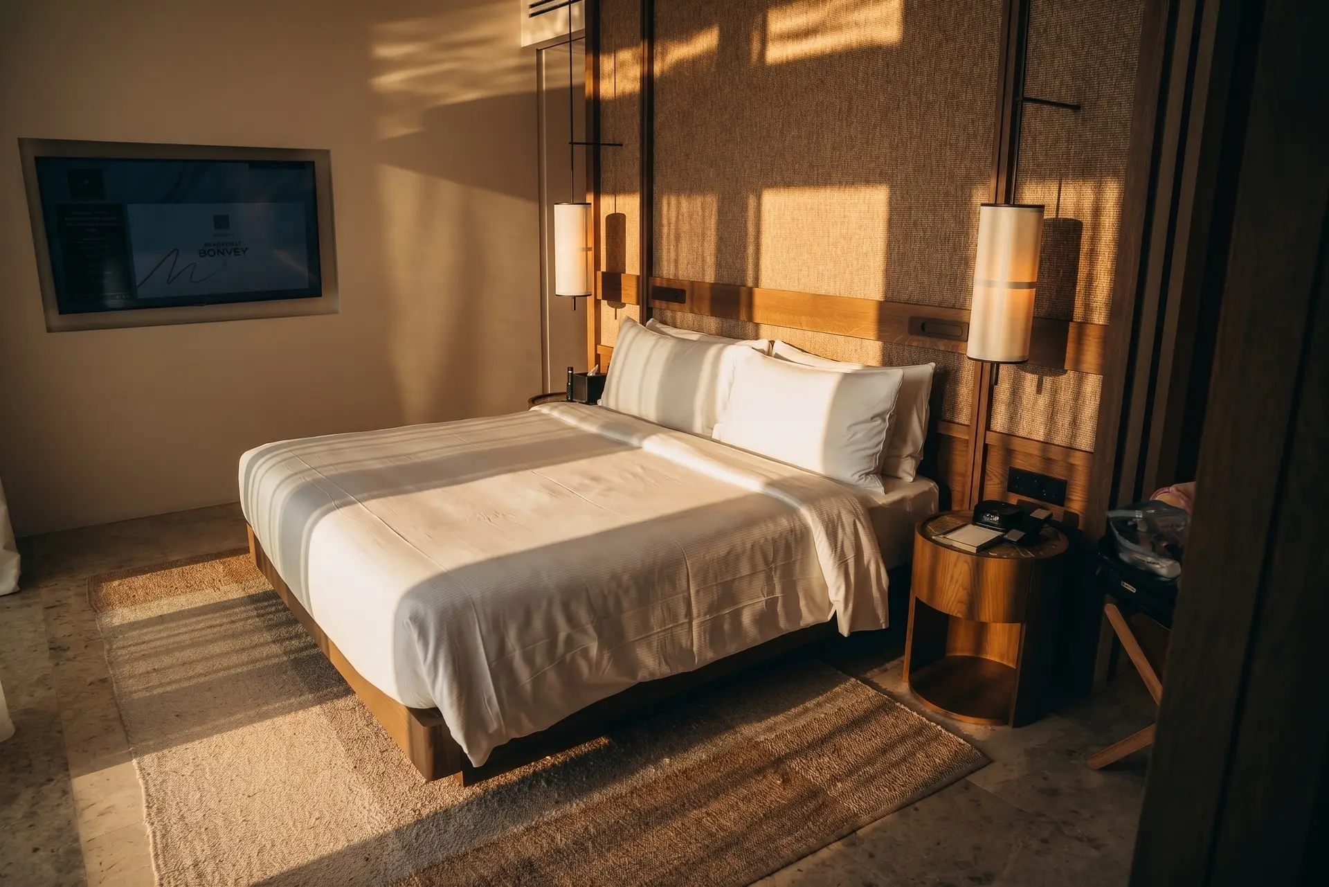 JW Marriott Crete Resort & Spa: The Complete Guide to Greece’s First JW Marriott 3 King bed in the Deluxe Suite at JW Marriott Crete, with wood-panelled headboard in the evening light