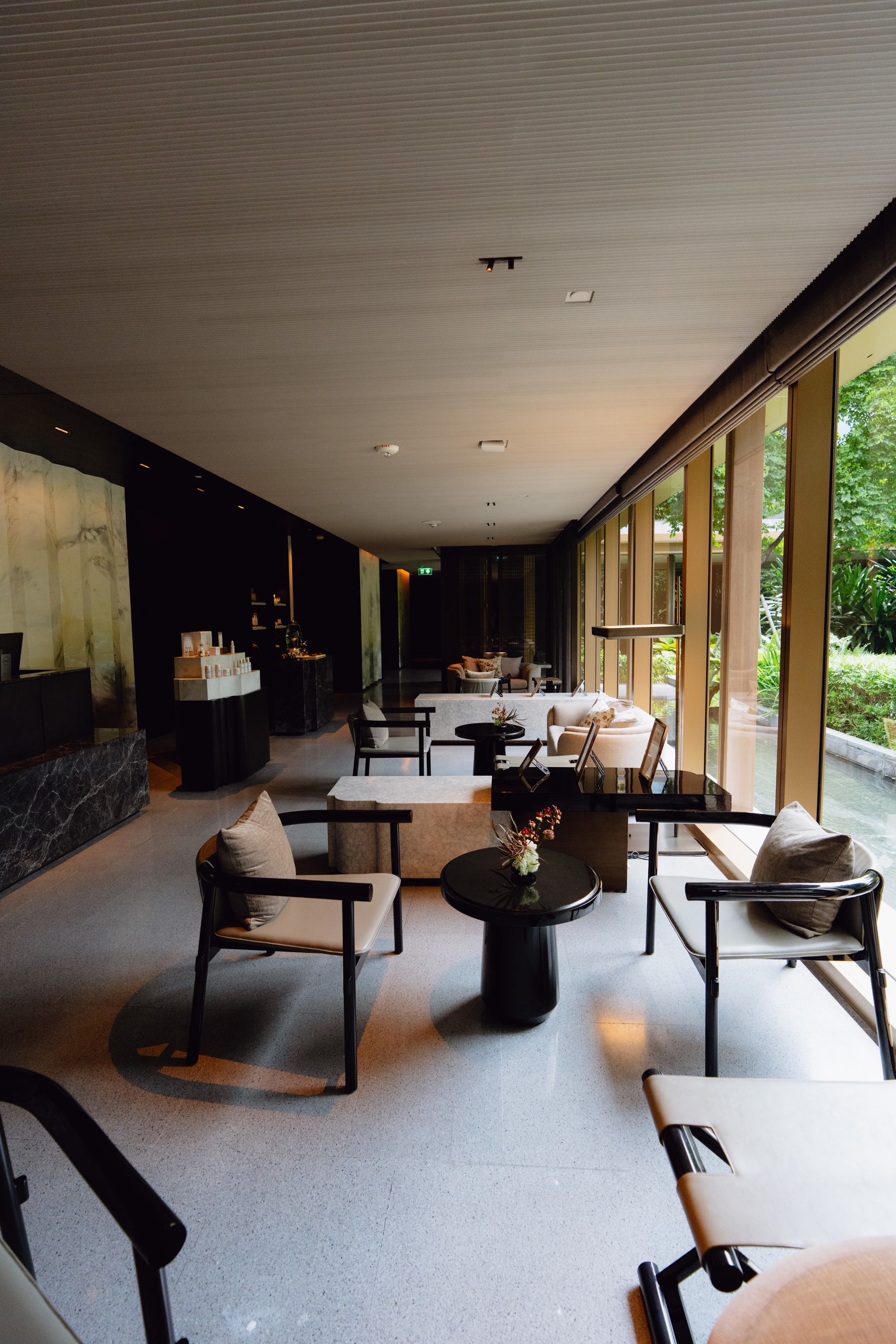 Bright lounge with armchairs and garden windows at Auriga Wellness, Capella Bangkok