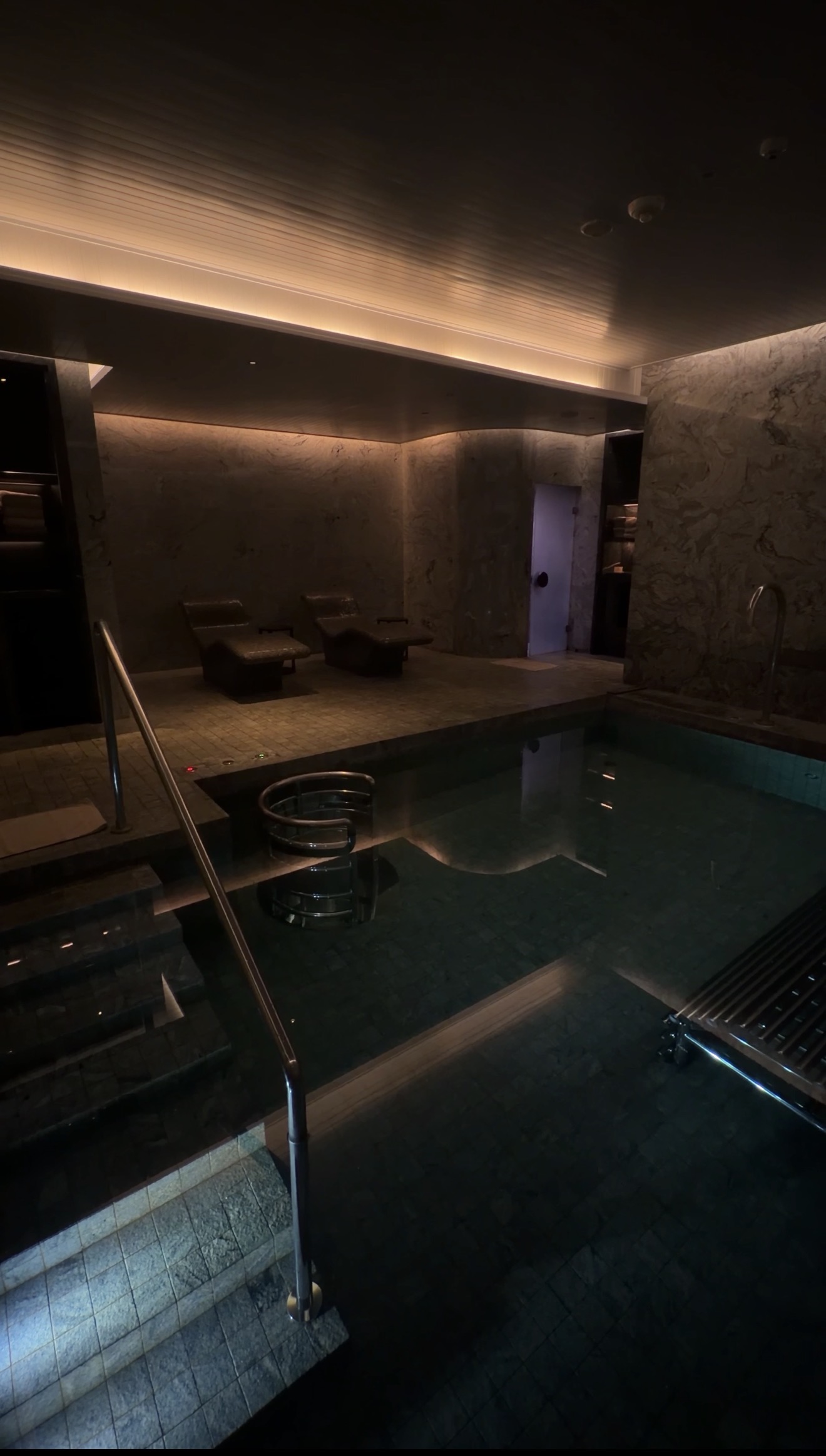 Warm vitality pool with loungers inside the Auriga Wellness spa at Capella Bangkok