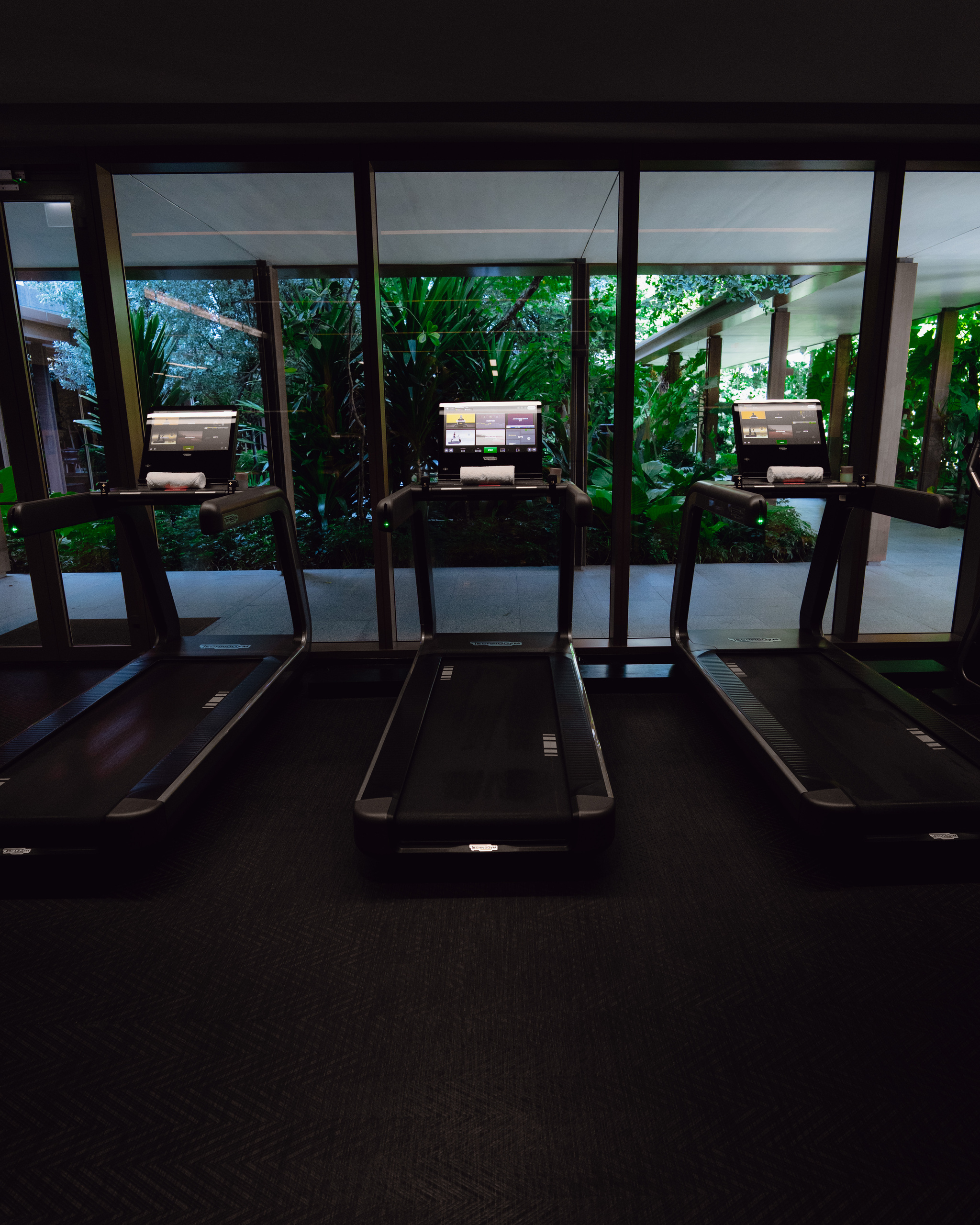 Treadmills facing the tropical garden in the gym at Capella Bangkok