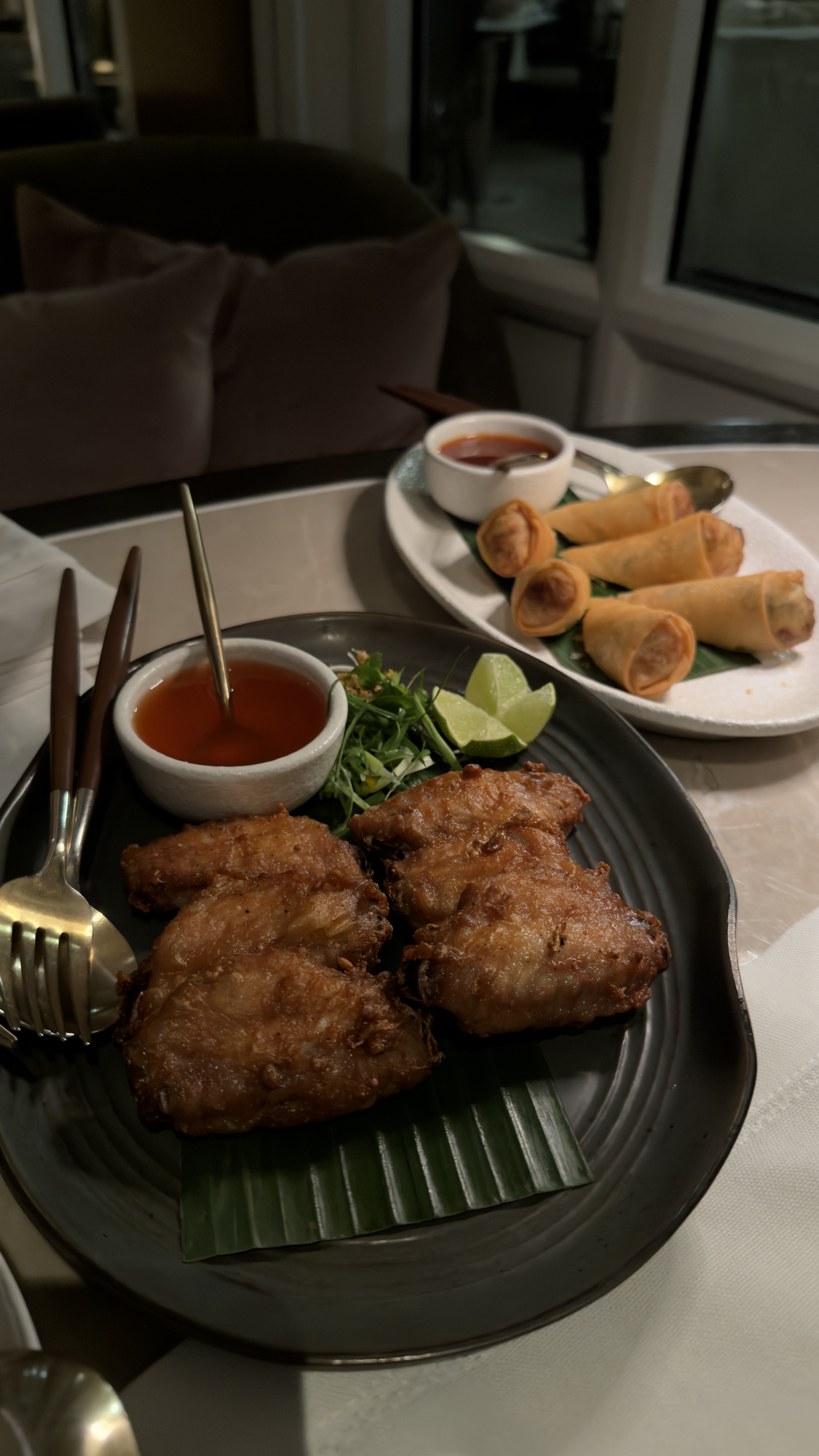 Fried chicken wings and crispy spring rolls on the table at Phra Nakhon, Capella Bangkok