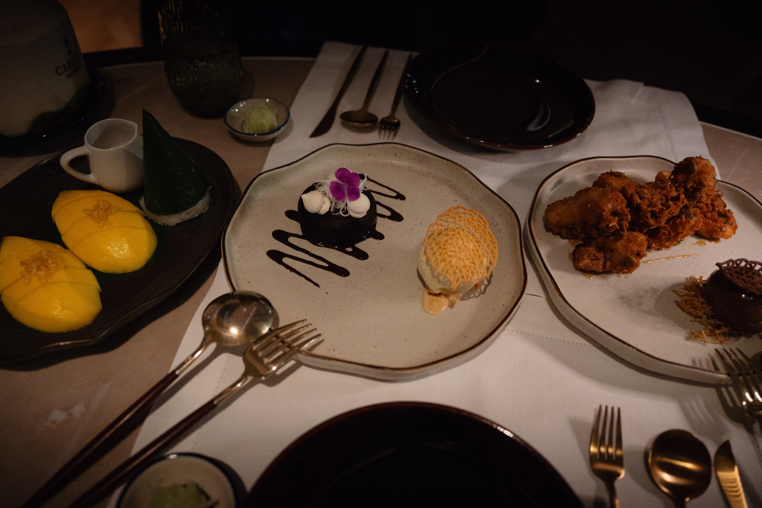 Mango sticky rice, chocolate lava pudding and fried bananas on the dinner table at Phra Nakhon, Capella Bangkok