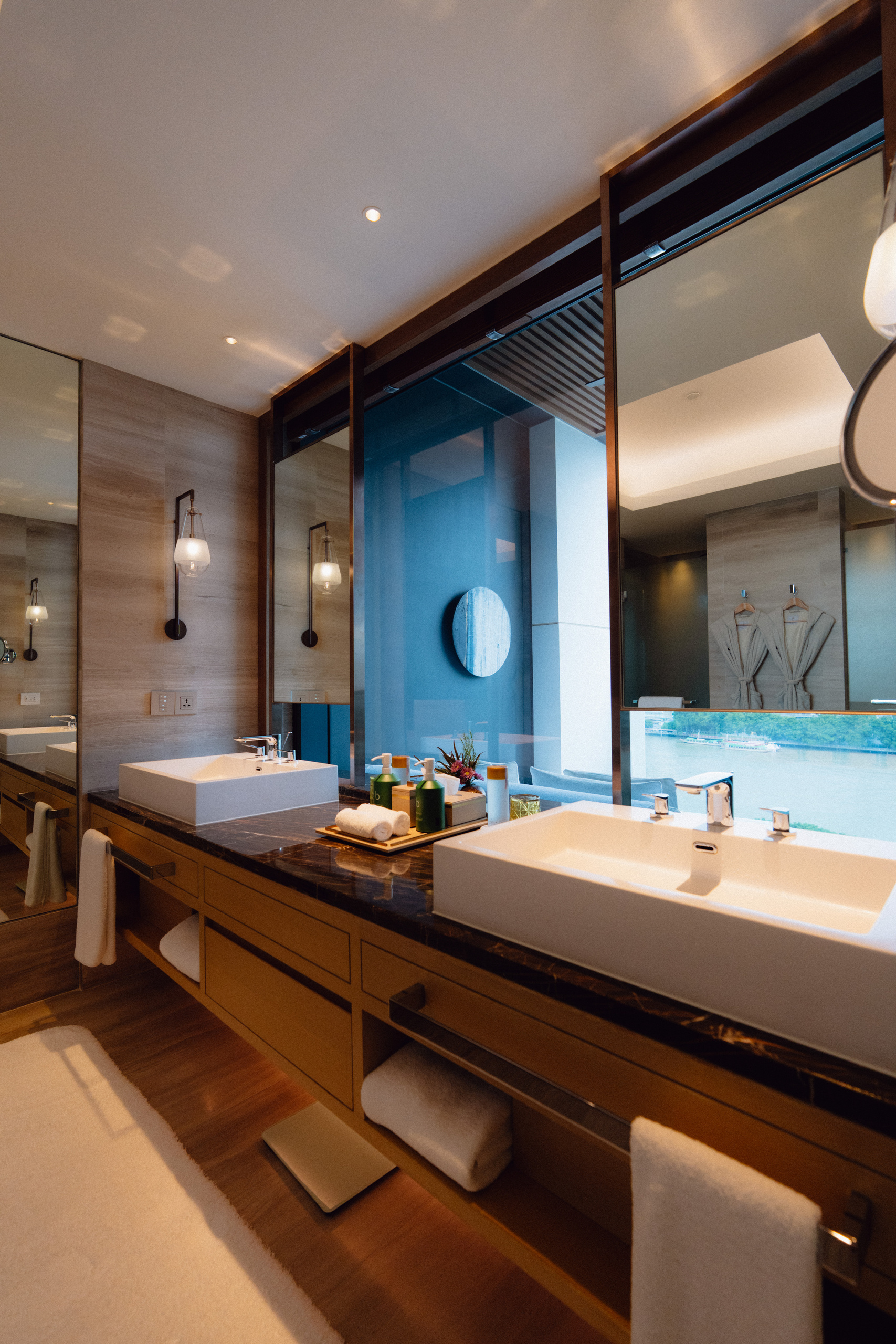 Double vanity with a view of the Chao Phraya River in the Riverfront Premier bathroom at Capella Bangkok