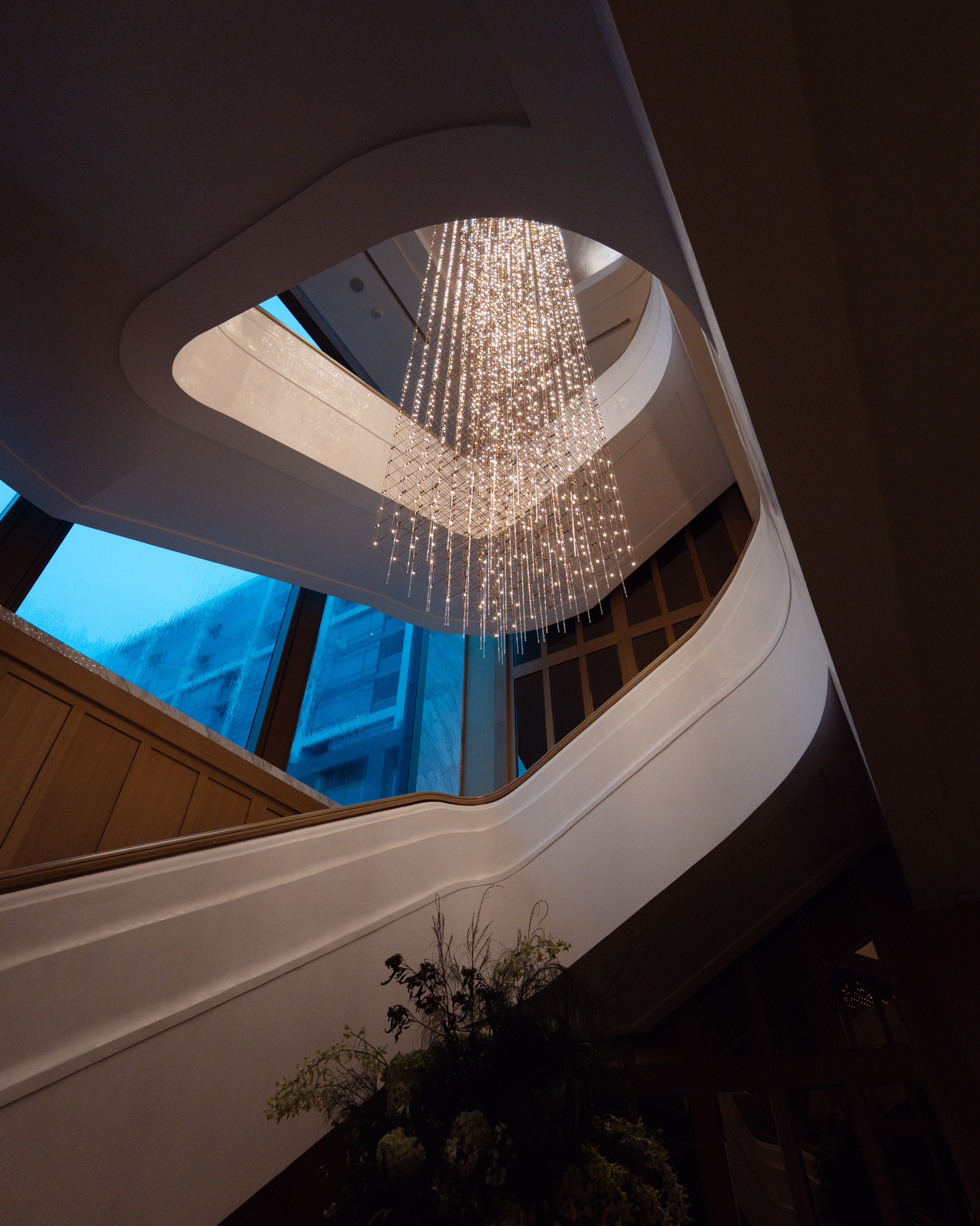 Curving staircase under a cascading light installation at Capella Bangkok