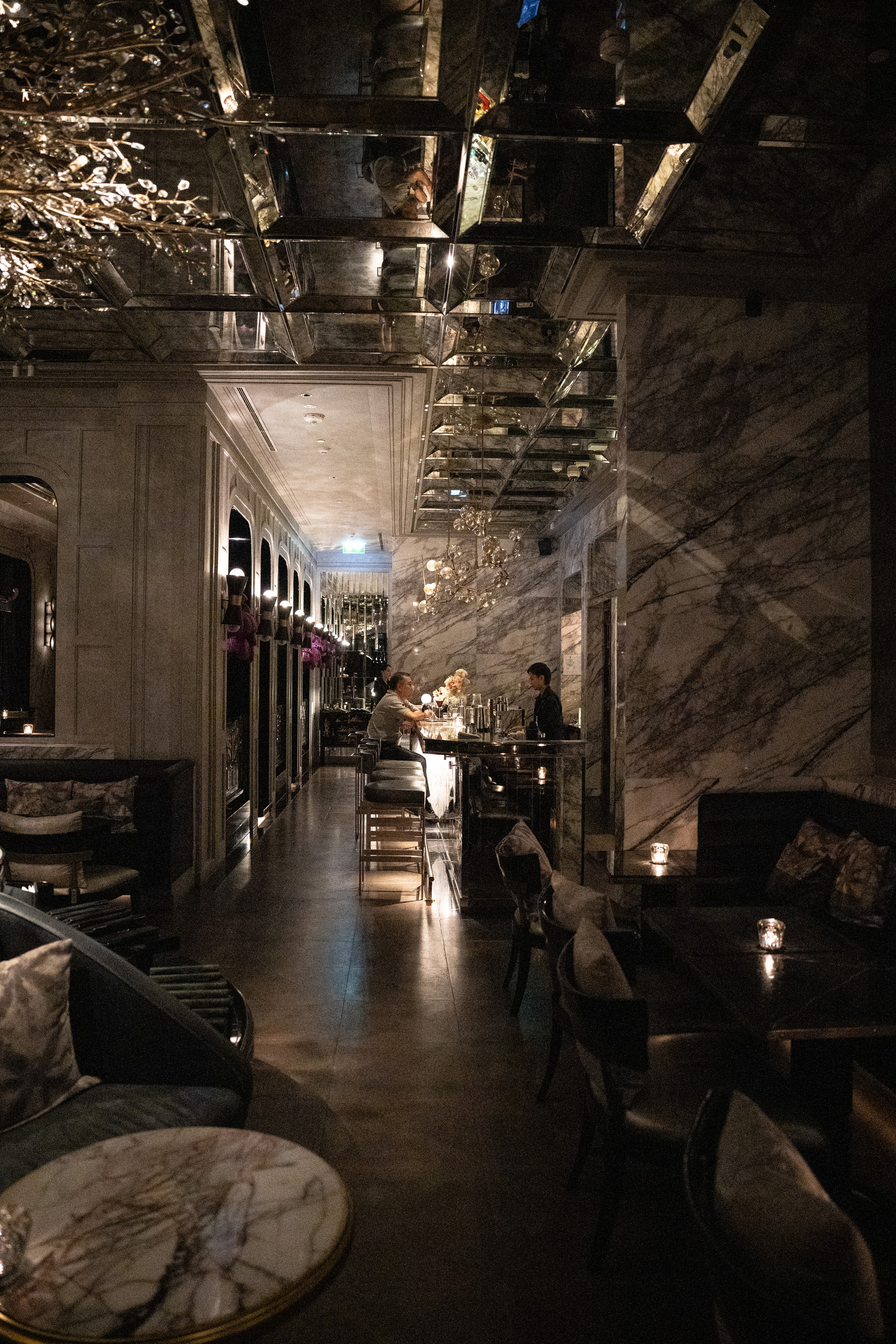 The long bar at Stella in Capella Bangkok under a mirrored ceiling
