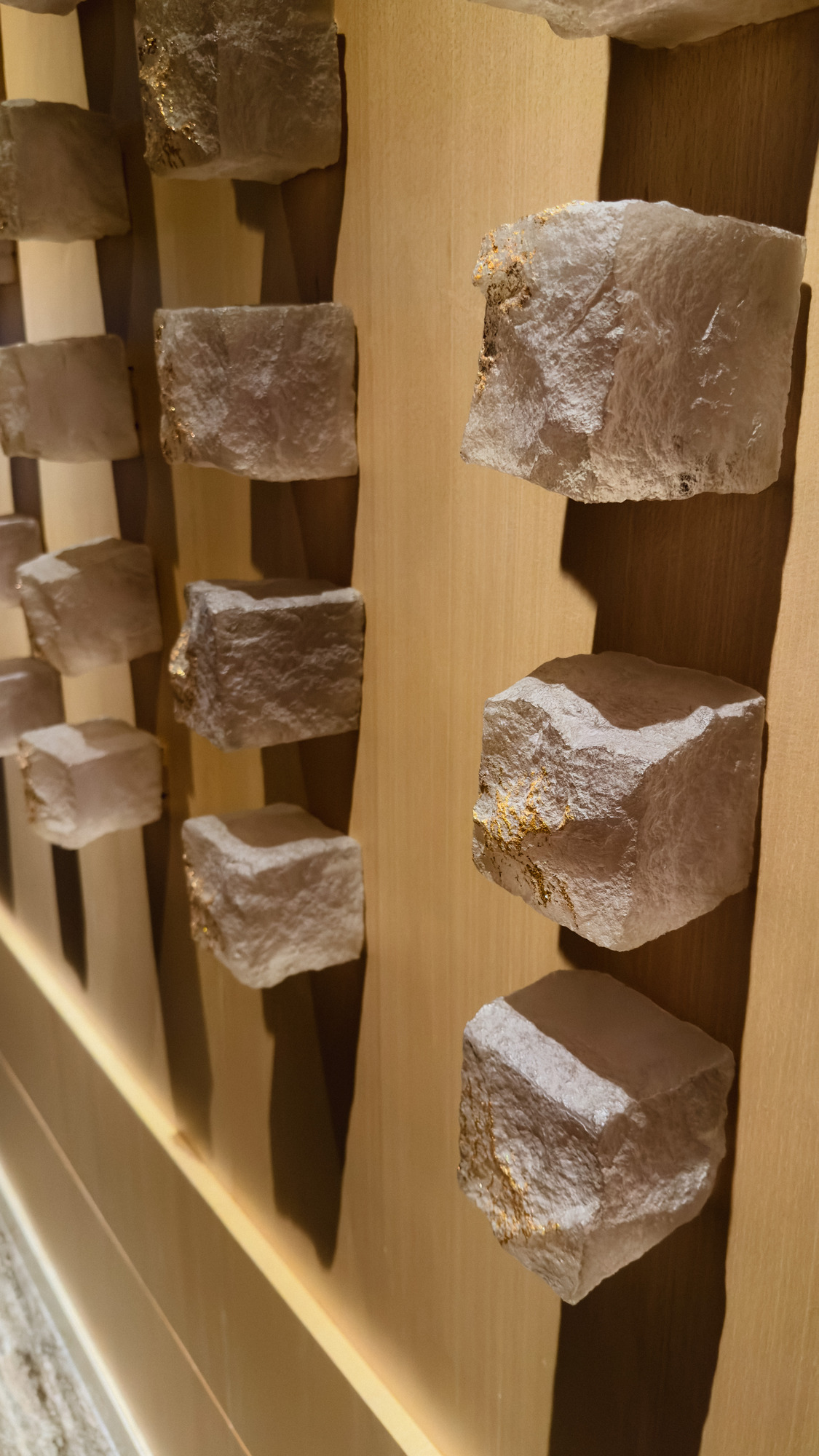Stone artwork on a wooden wall in one of the corridors at Capella Bangkok