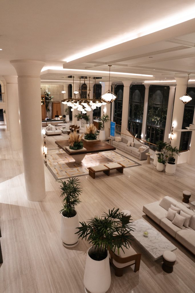 Centara Reserve Samui lobby at night with white columns, chandeliers and sofas