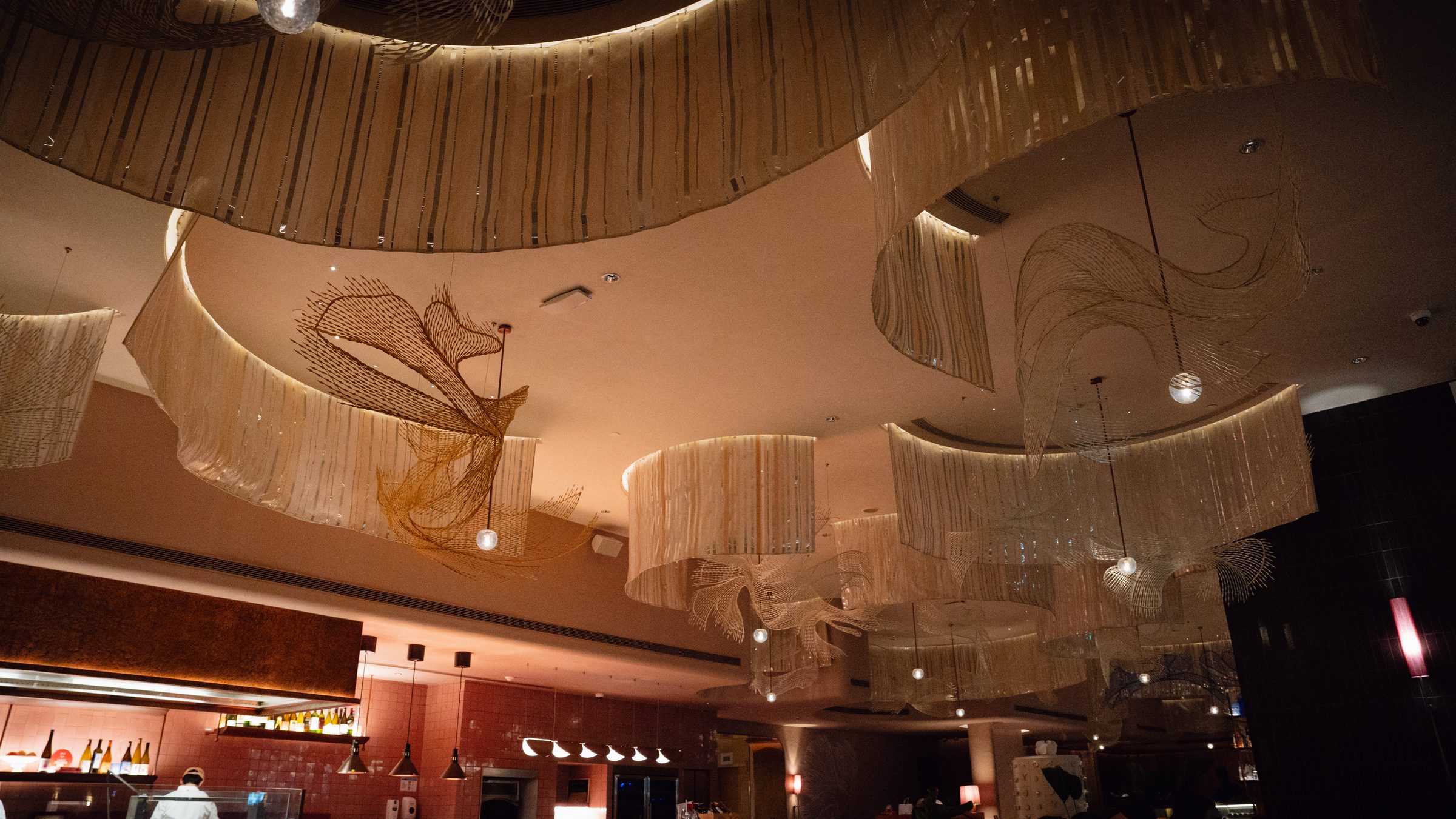 KROMO Bangkok Colette dining room with Siamese fighting fish sculptures on the ceiling