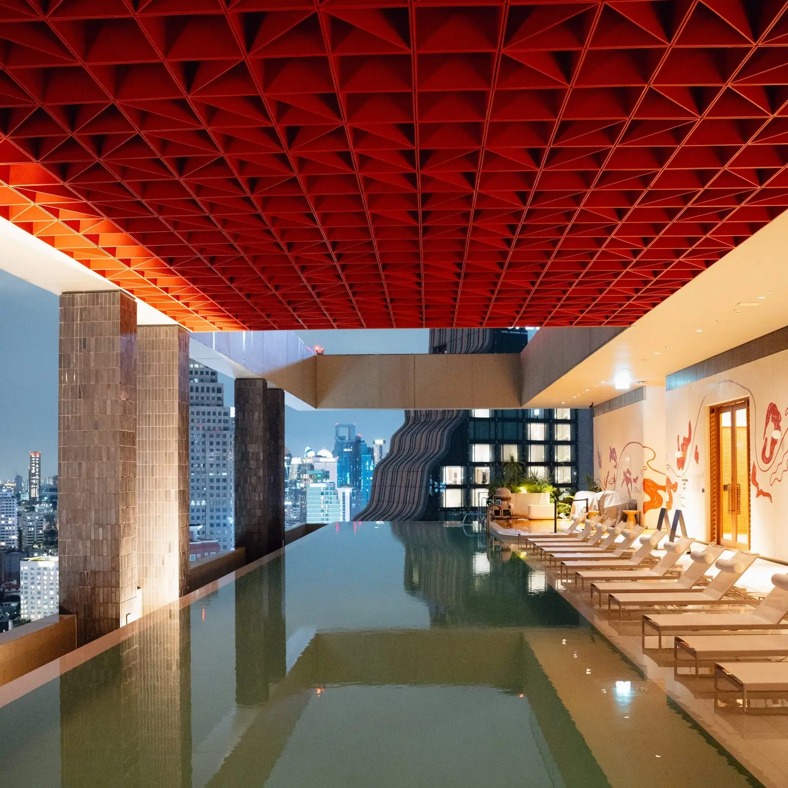 KROMO Bangkok rooftop infinity pool red ceiling skyline