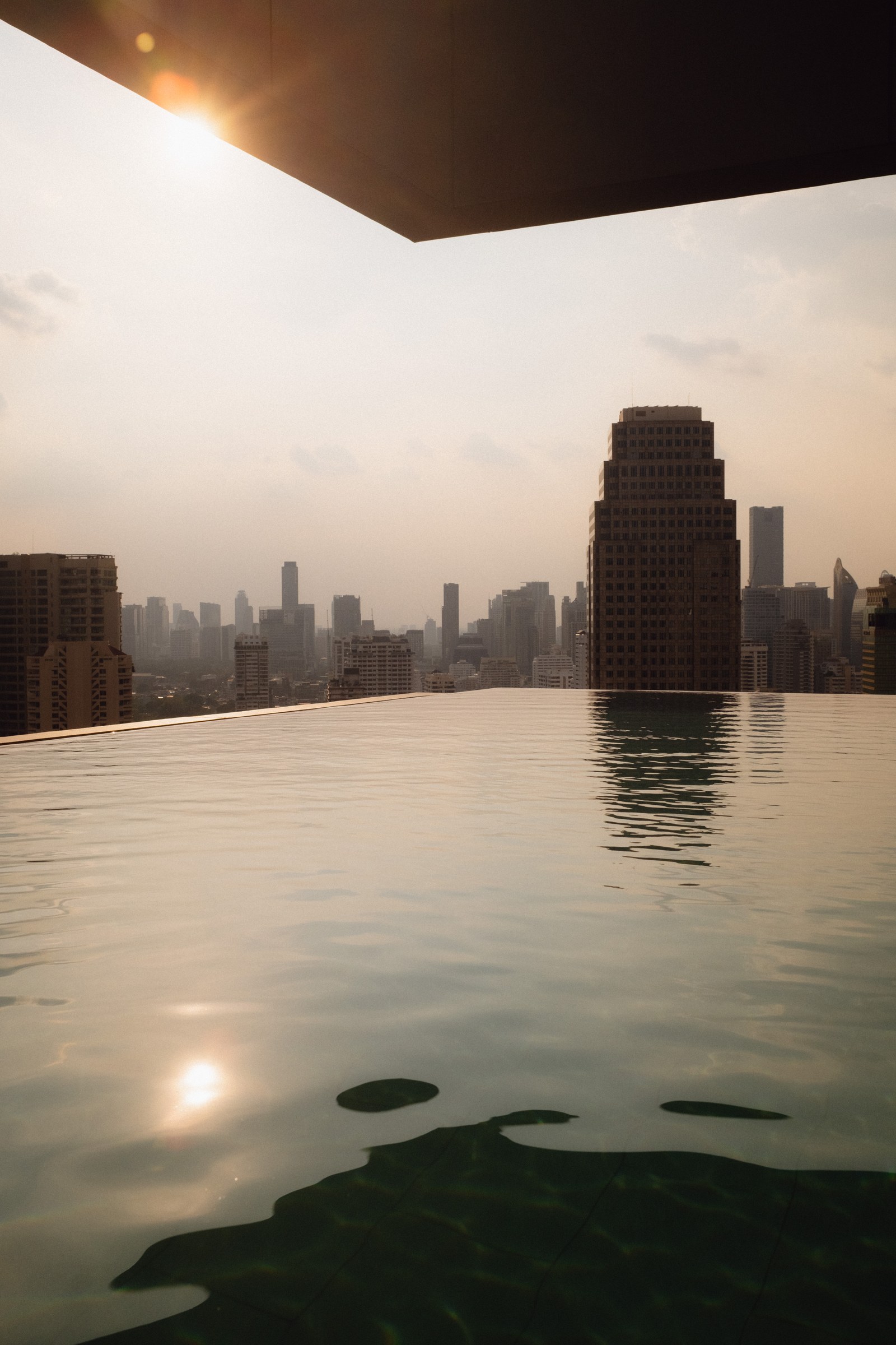 KROMO Bangkok rooftop infinity pool at sunset with city view