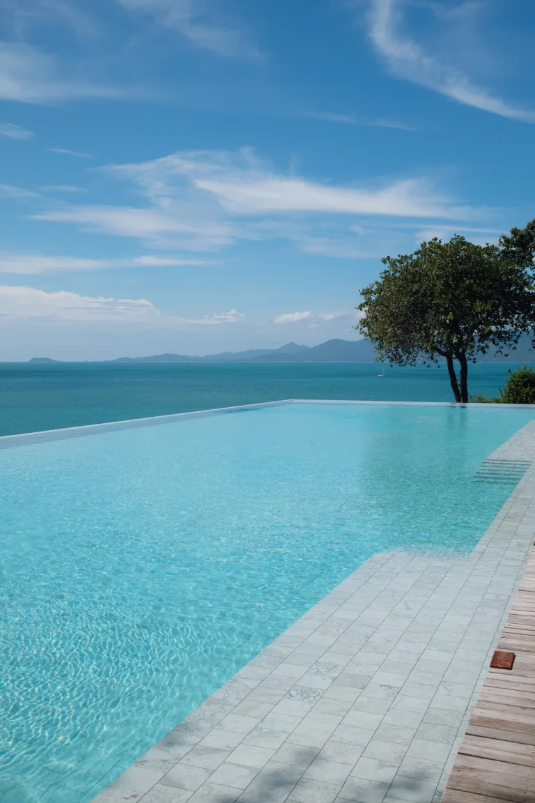 Six Senses Samui infinity pool with a tree at its edge and the sea and islands beyond